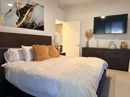 a bedroom with a bed and flat screen tv