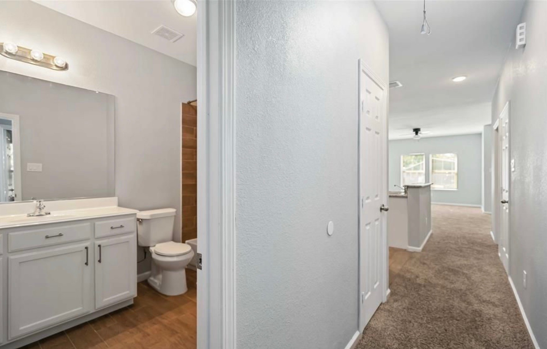 5101 Southwind Street Houston, TX 77033 - Photo 8 of 11 a bathroom with a granite countertop toilet a sink and a mirror