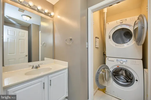 a bathroom with a sink a mirror and a washer dryer