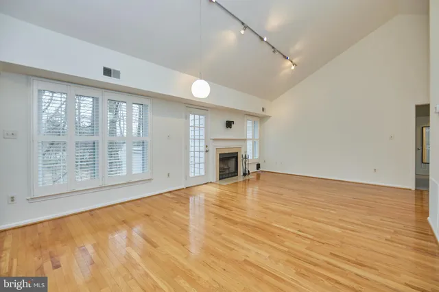 a view of empty room with wooden floor and a fireplace