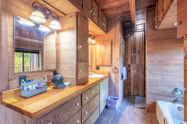 a spacious bathroom with a double vanity sink a mirror and a bathtub
