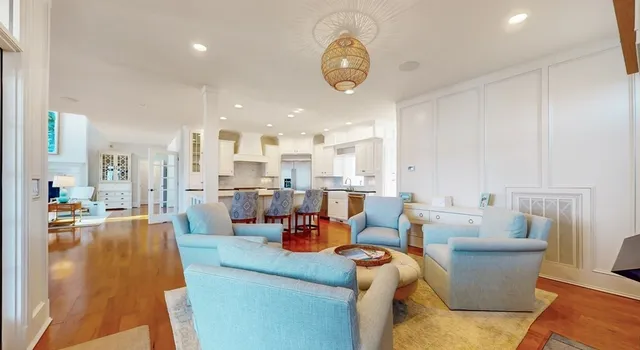 a large kitchen with stainless steel appliances kitchen island granite countertop a large kitchen island a stove a refrigerator and white cabinets