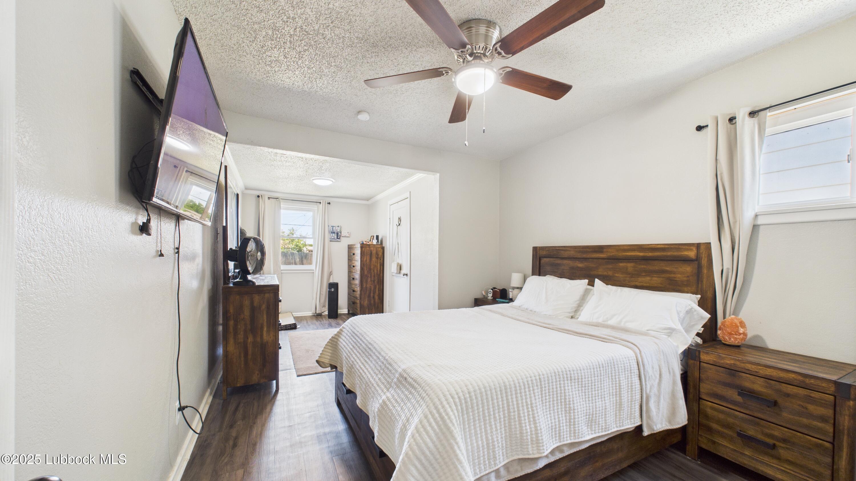 5310 24th Street Lubbock, TX 79407 - Photo 18 of 34 a bedroom with a large bed and a chandelier