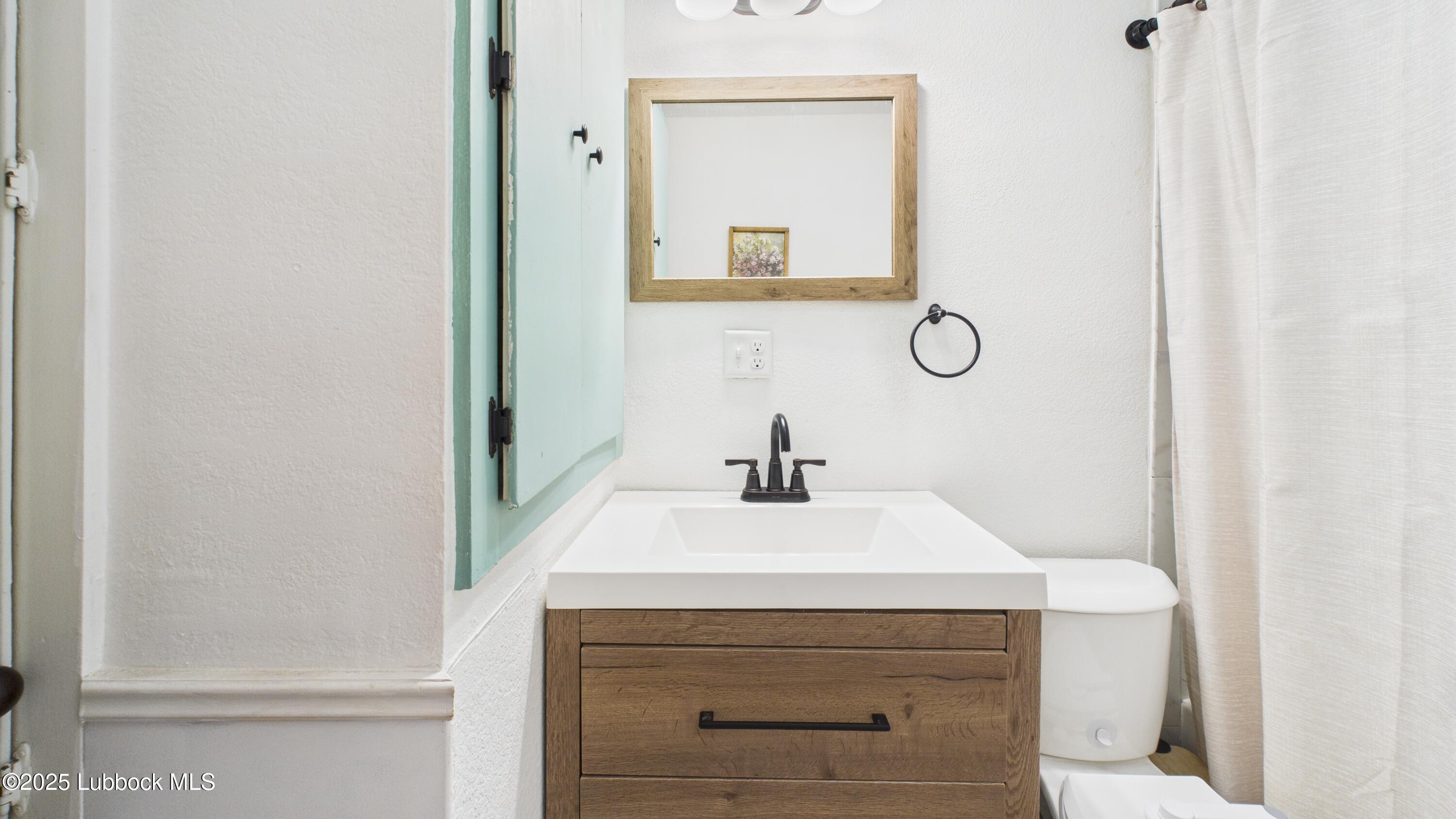 5310 24th Street Lubbock, TX 79407 - Photo 25 of 34 a bathroom with a sink and a mirror