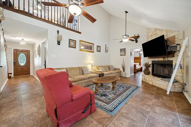 a living room with furniture a flat screen tv and a fireplace