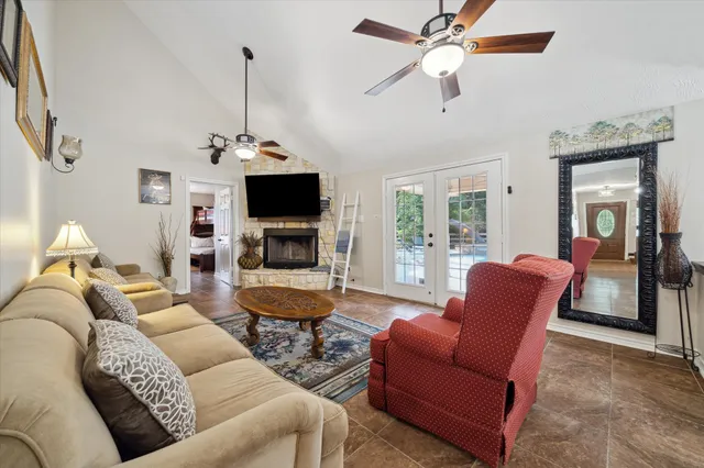 a living room with furniture a ceiling fan and a flat screen tv