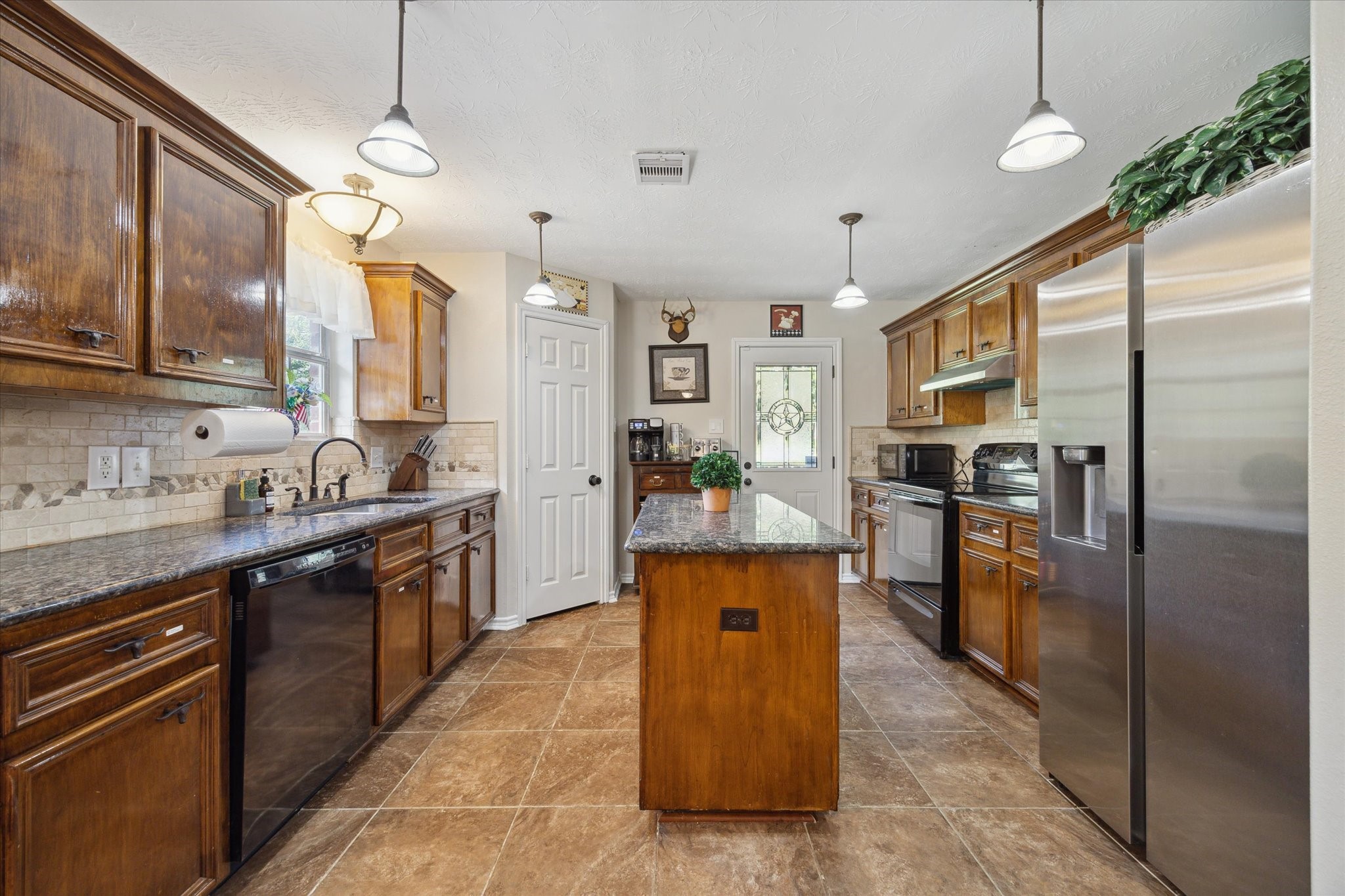 19215 Veterans Road Magnolia, TX 77355 - Photo 14 of 50 a kitchen with stainless steel appliances granite countertop a sink a stove and a refrigerator