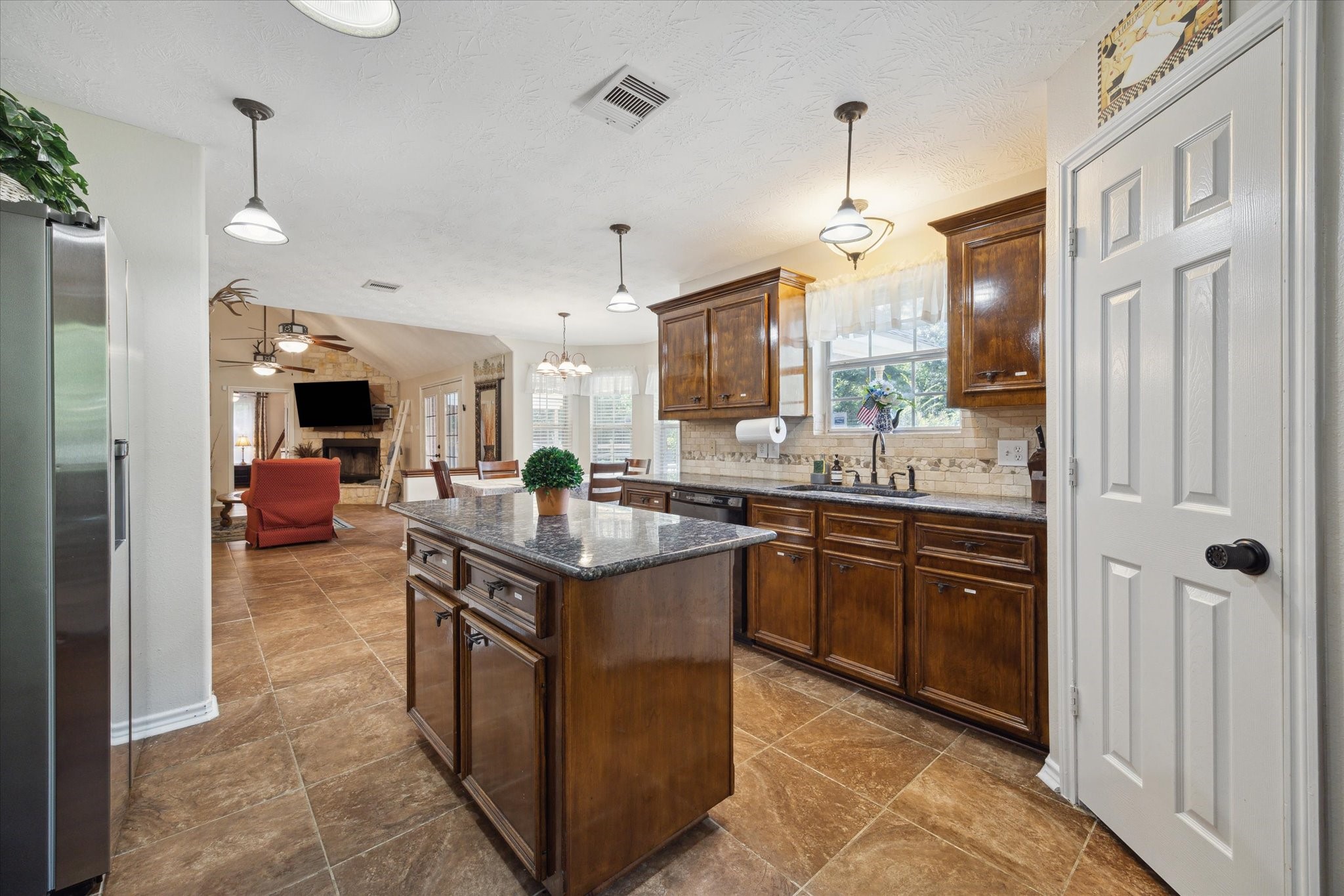 19215 Veterans Road Magnolia, TX 77355 - Photo 16 of 50 a kitchen with stainless steel appliances granite countertop a sink and a refrigerator