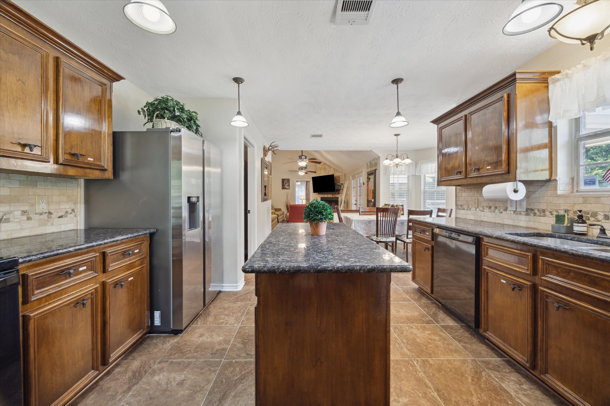 19215 Veterans Road Magnolia, TX 77355 - Photo 17 of 50 a kitchen with stainless steel appliances granite countertop a refrigerator a sink dishwasher a oven and a dining table with wooden floor