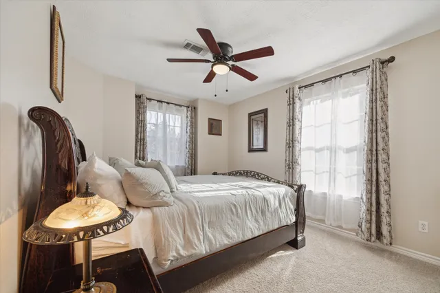 a bedroom with a bed and dresser with mirror