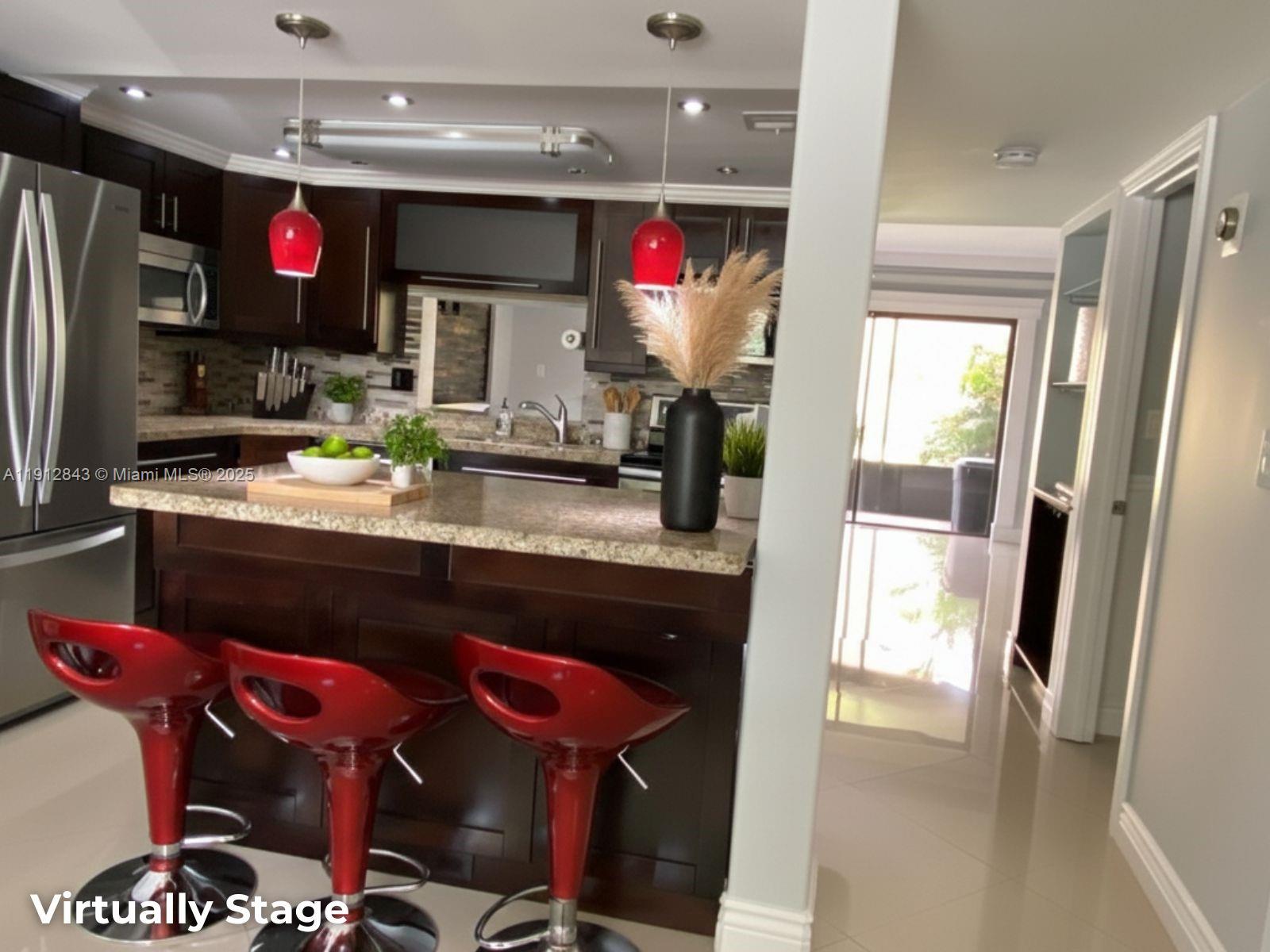 3282 North Pine Island Road, Unit 301 Sunrise, FL 33351 - Photo 3 of 25 a kitchen with stainless steel appliances granite countertop a sink and a refrigerator