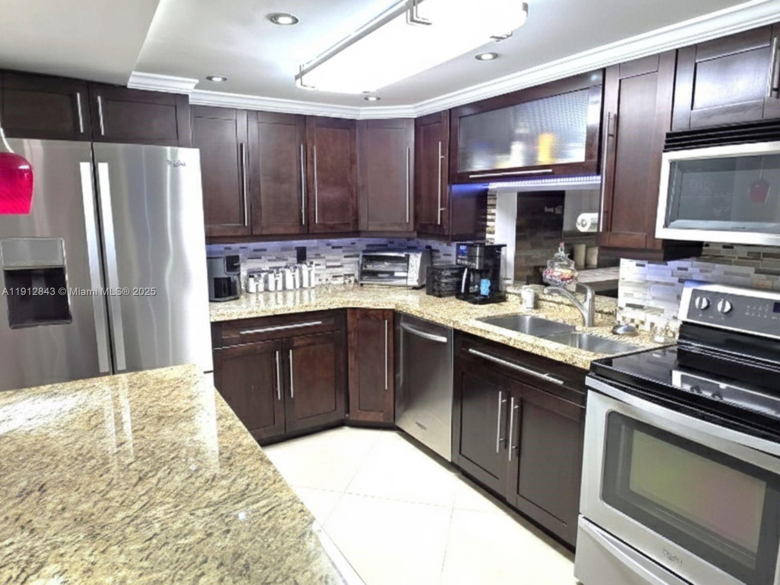 3282 North Pine Island Road, Unit 301 Sunrise, FL 33351 - Photo 5 of 25 a kitchen with a sink stove and refrigerator