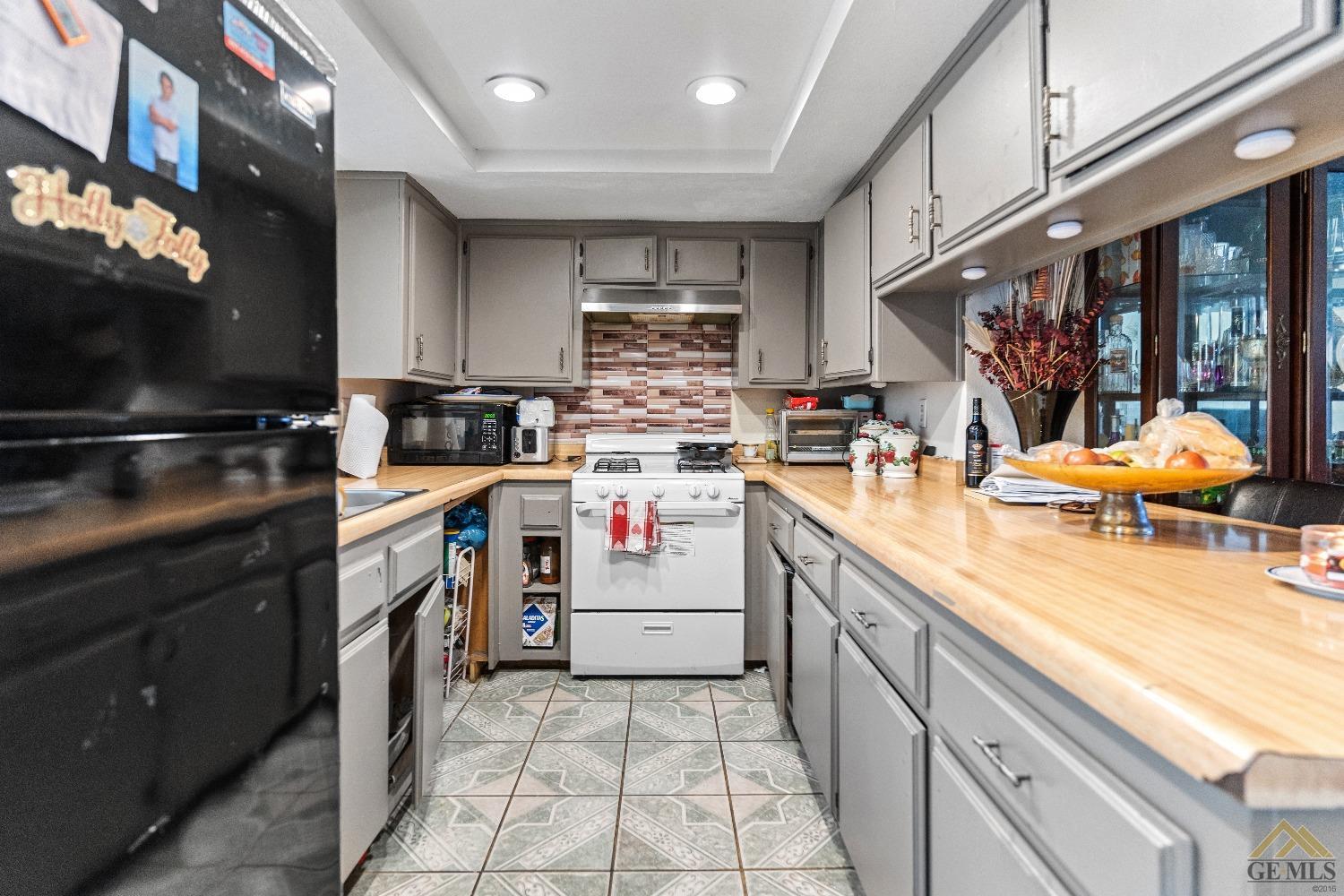 Undisclosed Address Bakersfield, CA 93304 - Photo 12 of 19 a kitchen that has a lot of cabinets in it and wooden floors
