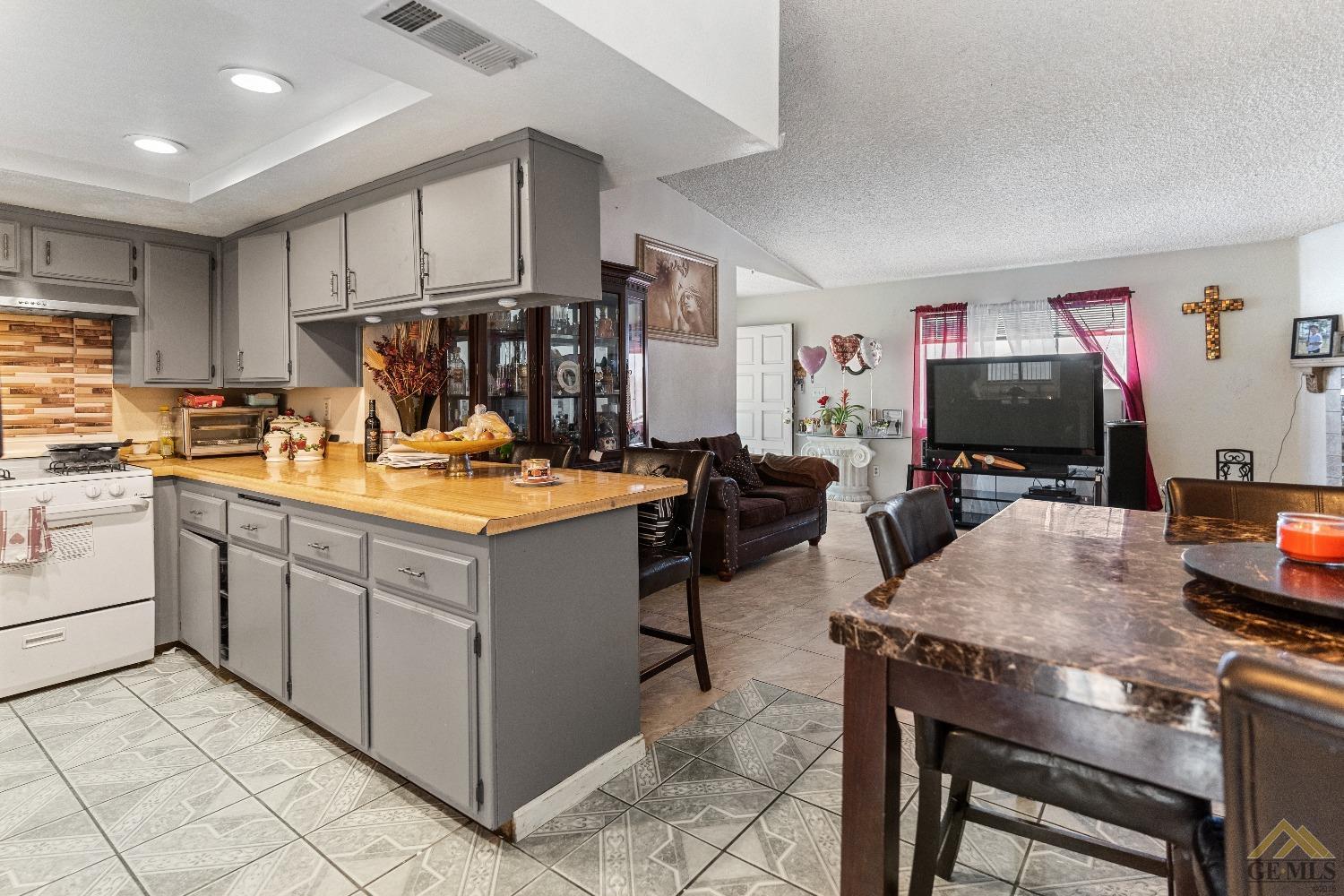 Undisclosed Address Bakersfield, CA 93304 - Photo 13 of 19 a room with kitchen island a table and chairs in it
