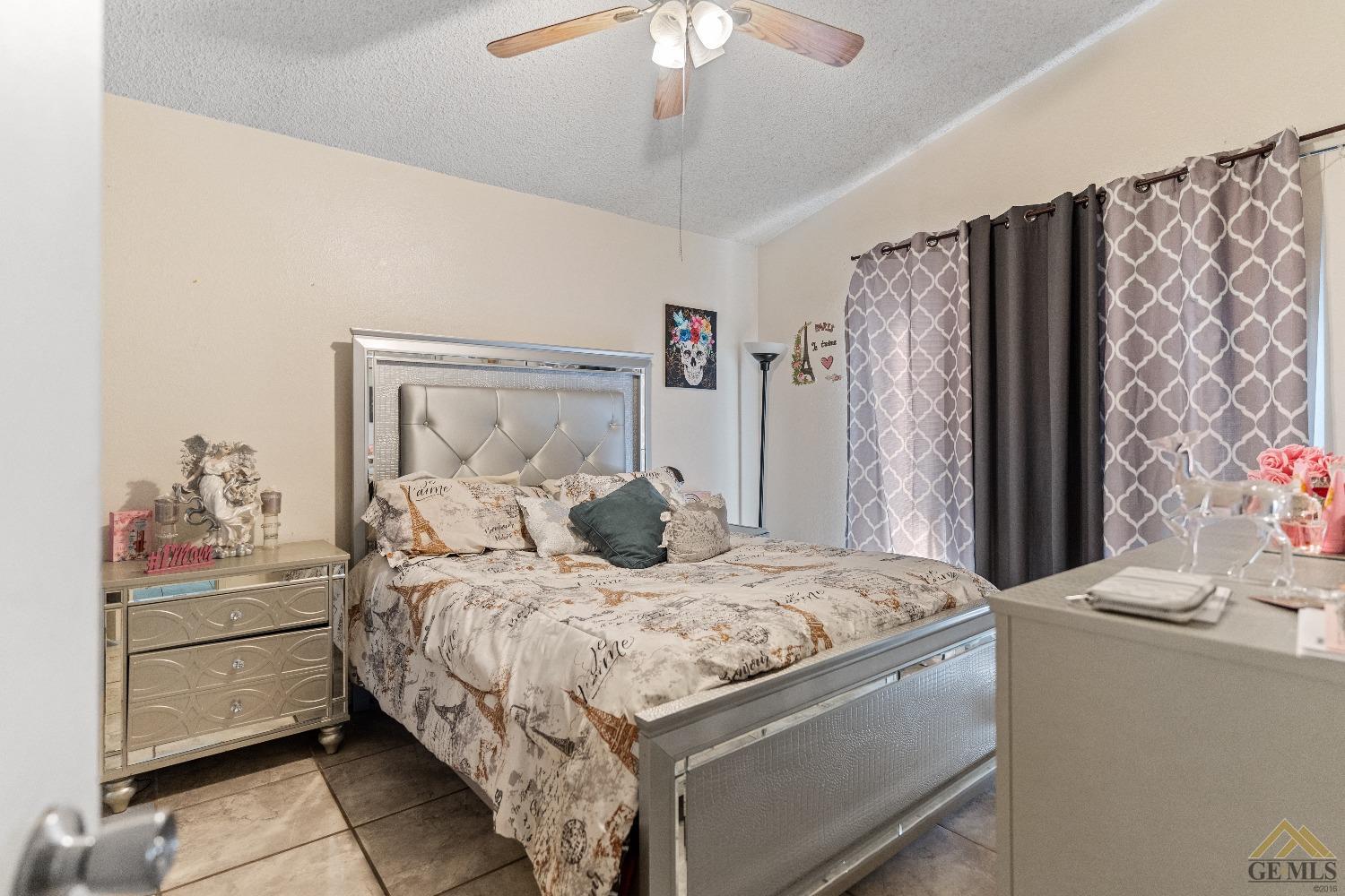 Undisclosed Address Bakersfield, CA 93304 - Photo 17 of 19 a bedroom with a large bed and a chandelier