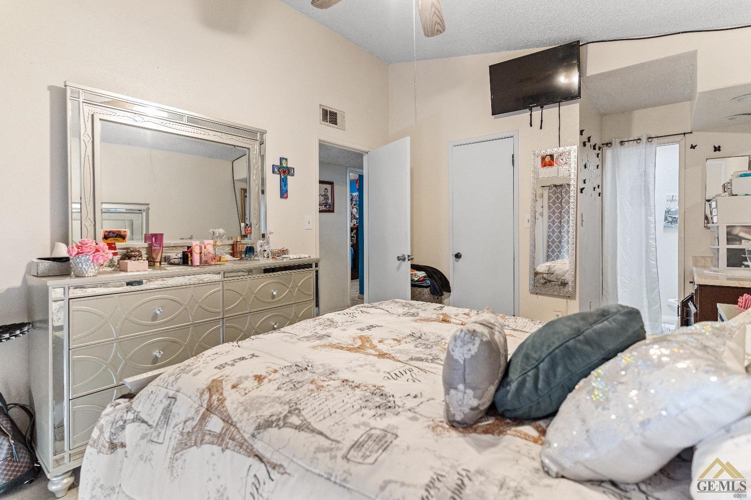 Undisclosed Address Bakersfield, CA 93304 - Photo 18 of 19 a large bedroom with a large bed and a large mirror