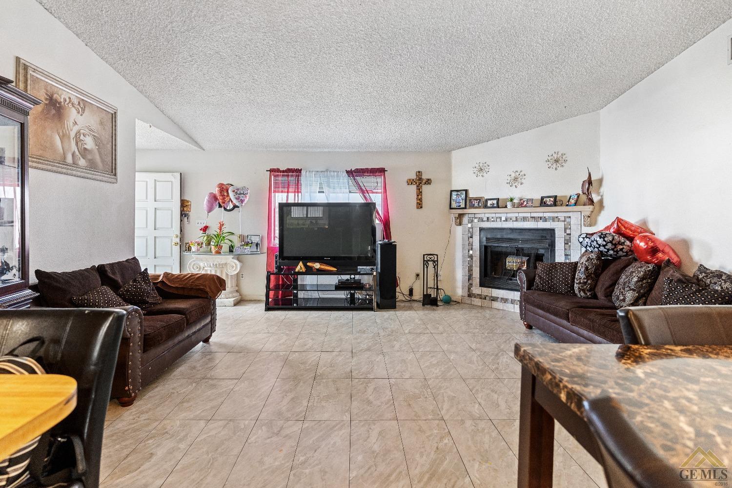 Undisclosed Address Bakersfield, CA 93304 - Photo 7 of 19 a living room with furniture a flat screen tv and a fireplace