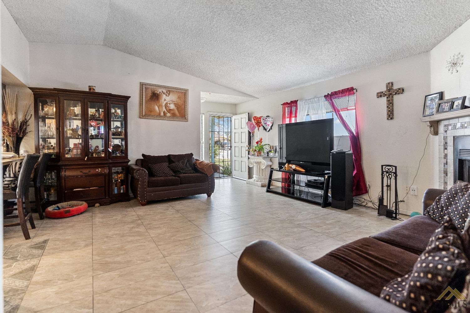 Undisclosed Address Bakersfield, CA 93304 - Photo 9 of 19 a living room with furniture a flat screen tv and a window