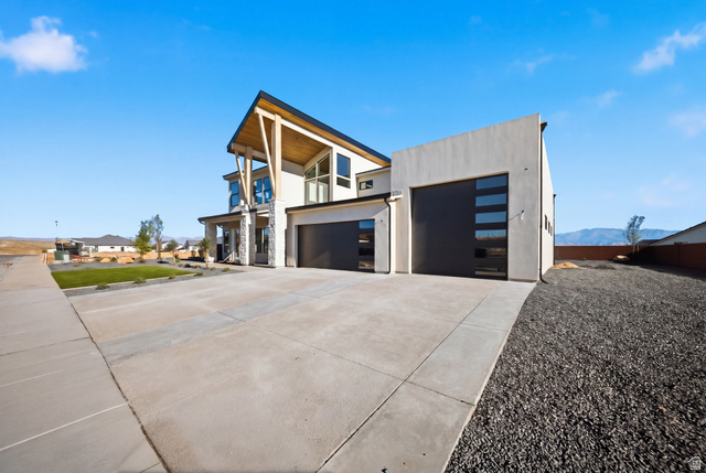 3011 East Rimrunner Drive, Unit 302 St. George, UT 84790 - Photo 5 of 45 View of home's exterior featuring a balcony, driveway, stucco siding, a mountain view, and a garage