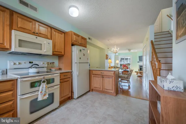 a kitchen with stainless steel appliances granite countertop a stove a sink dishwasher and a refrigerator