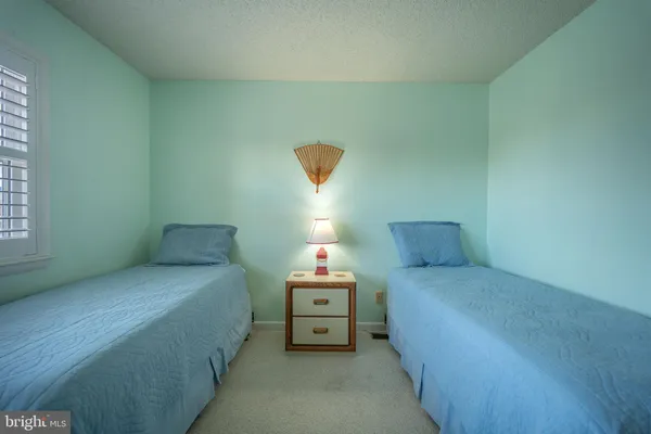 a bedroom with a bed and a lamp on dresser
