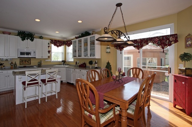 1560 Southgate Road Bartlett, IL 60103 - Photo 5 of 25 a dining room with wooden floor a chandelier a wooden table and chairs