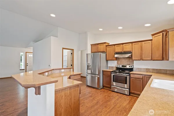 a kitchen with stainless steel appliances granite countertop a sink stove and refrigerator