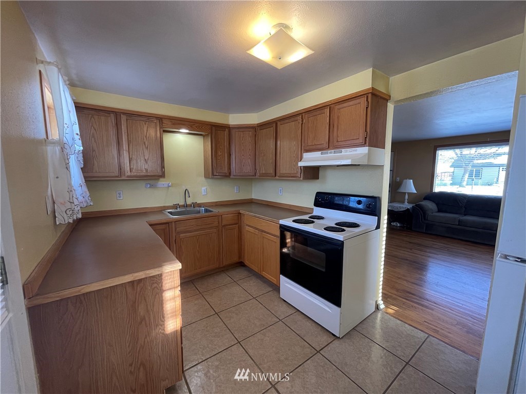 65 F Street Northeast Ephrata, WA 98823 - Photo 10 of 15 a kitchen with stainless steel appliances granite countertop a stove a sink dishwasher and a refrigerator