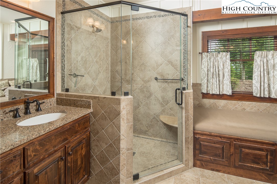 113 Pepperroot Road Boone, NC 28607 - Photo 16 of 50 a bathroom with a granite countertop sink a mirror and shower