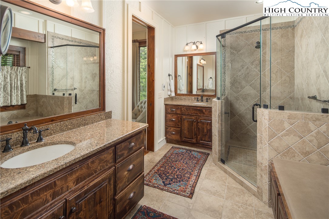 113 Pepperroot Road Boone, NC 28607 - Photo 17 of 50 a bathroom with a granite countertop sink a mirror and a shower