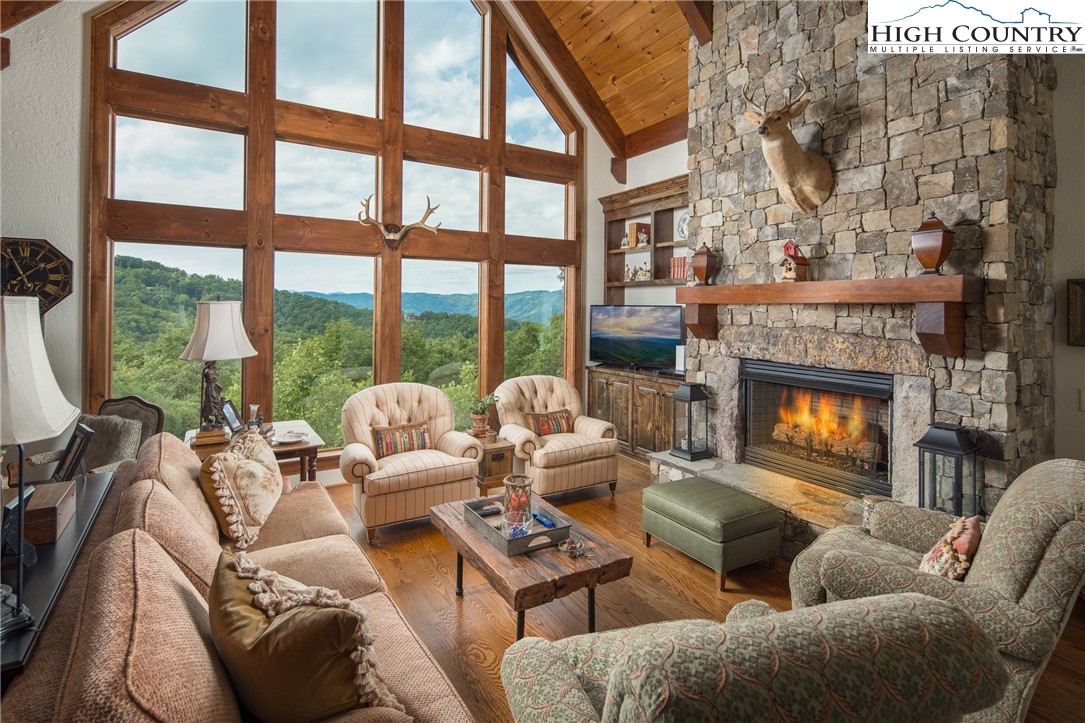 113 Pepperroot Road Boone, NC 28607 - Photo 2 of 50 a living room with furniture a floor to ceiling window and a fireplace