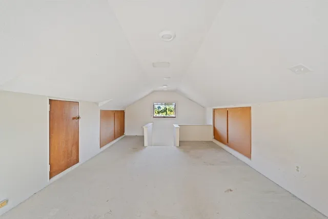 a view of a hallway with wooden floor and cabinet