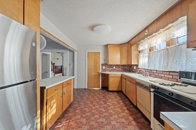 a kitchen with stainless steel appliances granite countertop a stove a sink and a refrigerator