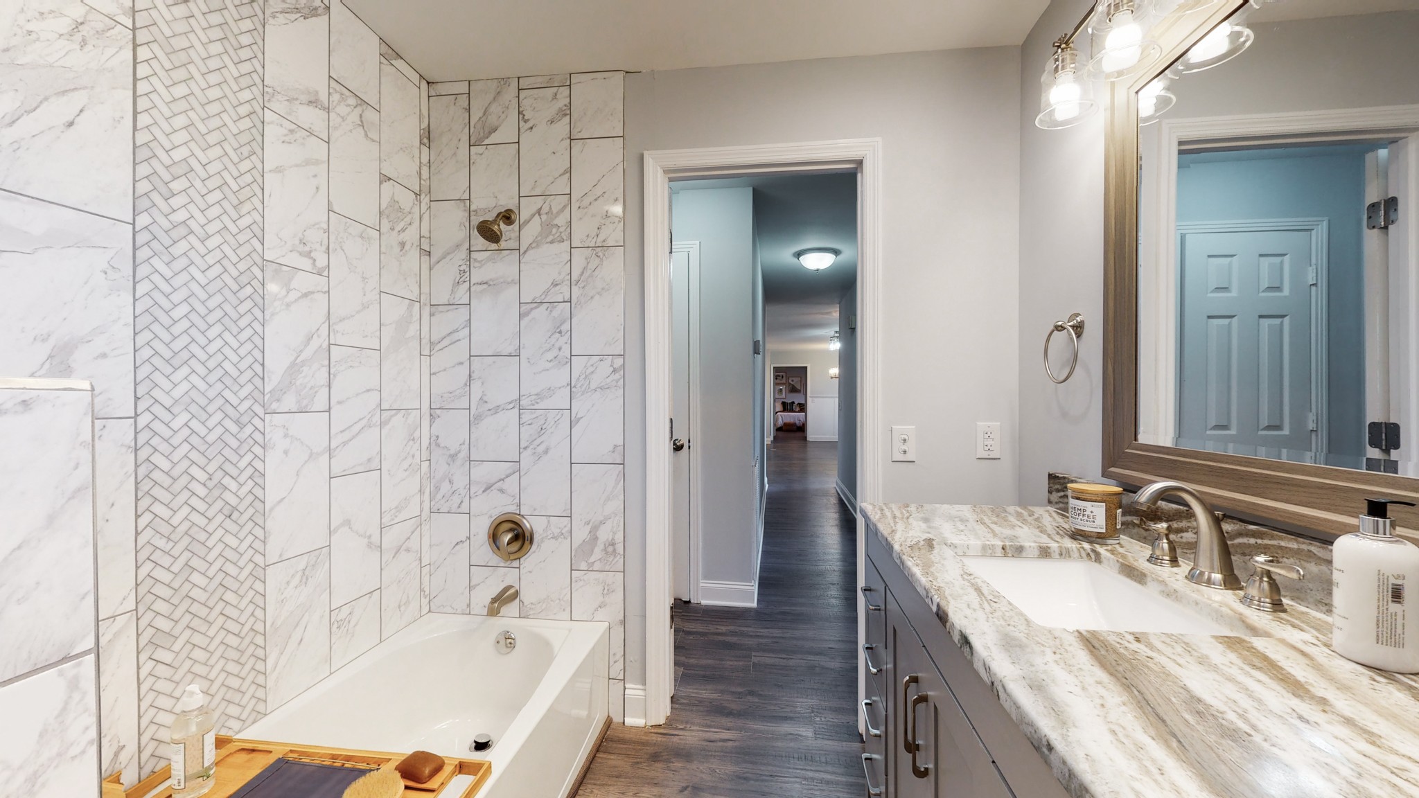 5514 Vanderbilt Road Old Hickory, TN 37138 - Photo 25 of 32 a bathroom with a granite countertop sink a mirror a bathtub and shower
