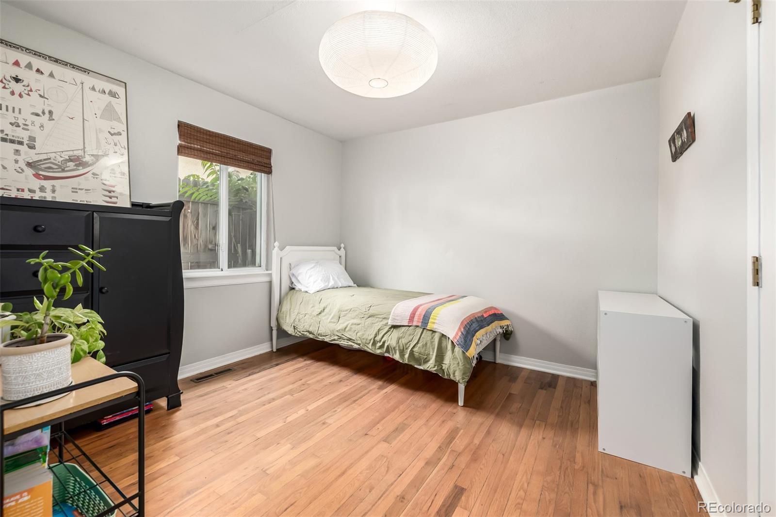 1800 Grove Street Denver, CO 80204 - Photo 11 of 35 a bedroom with a bed and a potted plant on the dresser