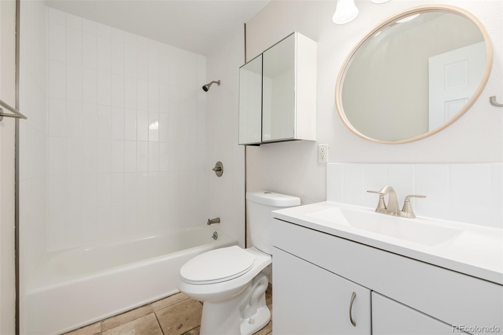 1800 Grove Street Denver, CO 80204 - Photo 8 of 35 a bathroom with a sink a toilet and a mirror