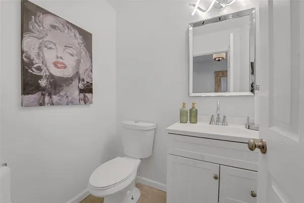 a bathroom with a toilet sink vanity and mirror
