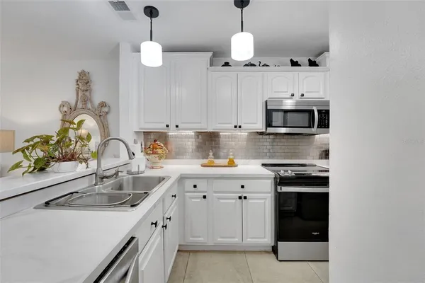 a kitchen with stainless steel appliances a sink a stove and a microwave