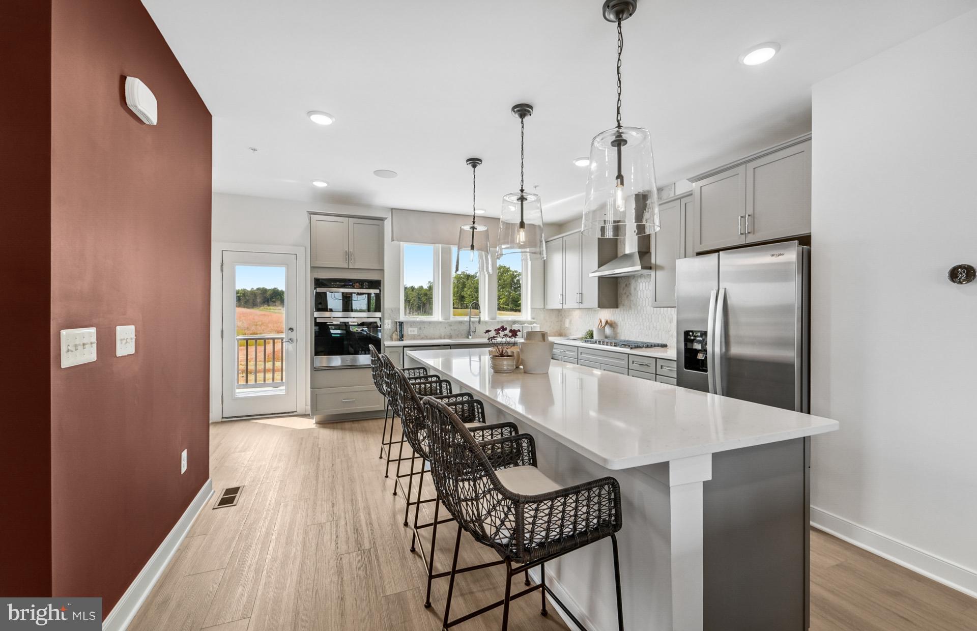 1311 Bracken Lane Laurel, MD 20724 - Photo 10 of 61 a kitchen with stainless steel appliances granite countertop a refrigerator a oven a sink a dining table and chairs with wooden floor