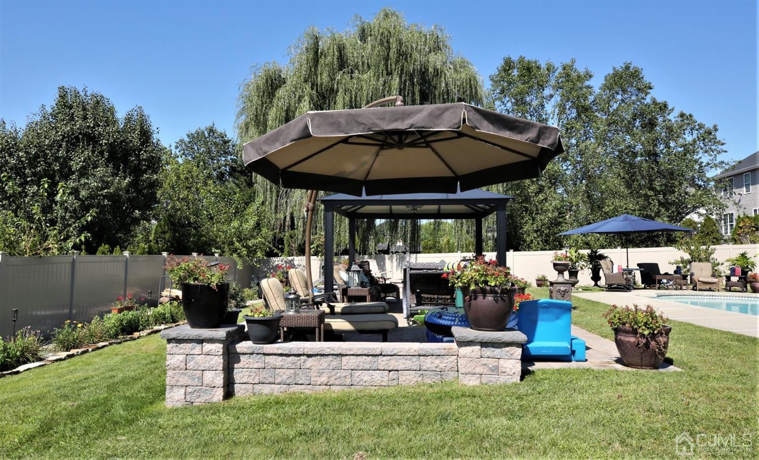 1 MacFarlane Circle Monroe Township, NJ 08831 - Photo 11 of 26 a view of patio with table and chairs under an umbrella