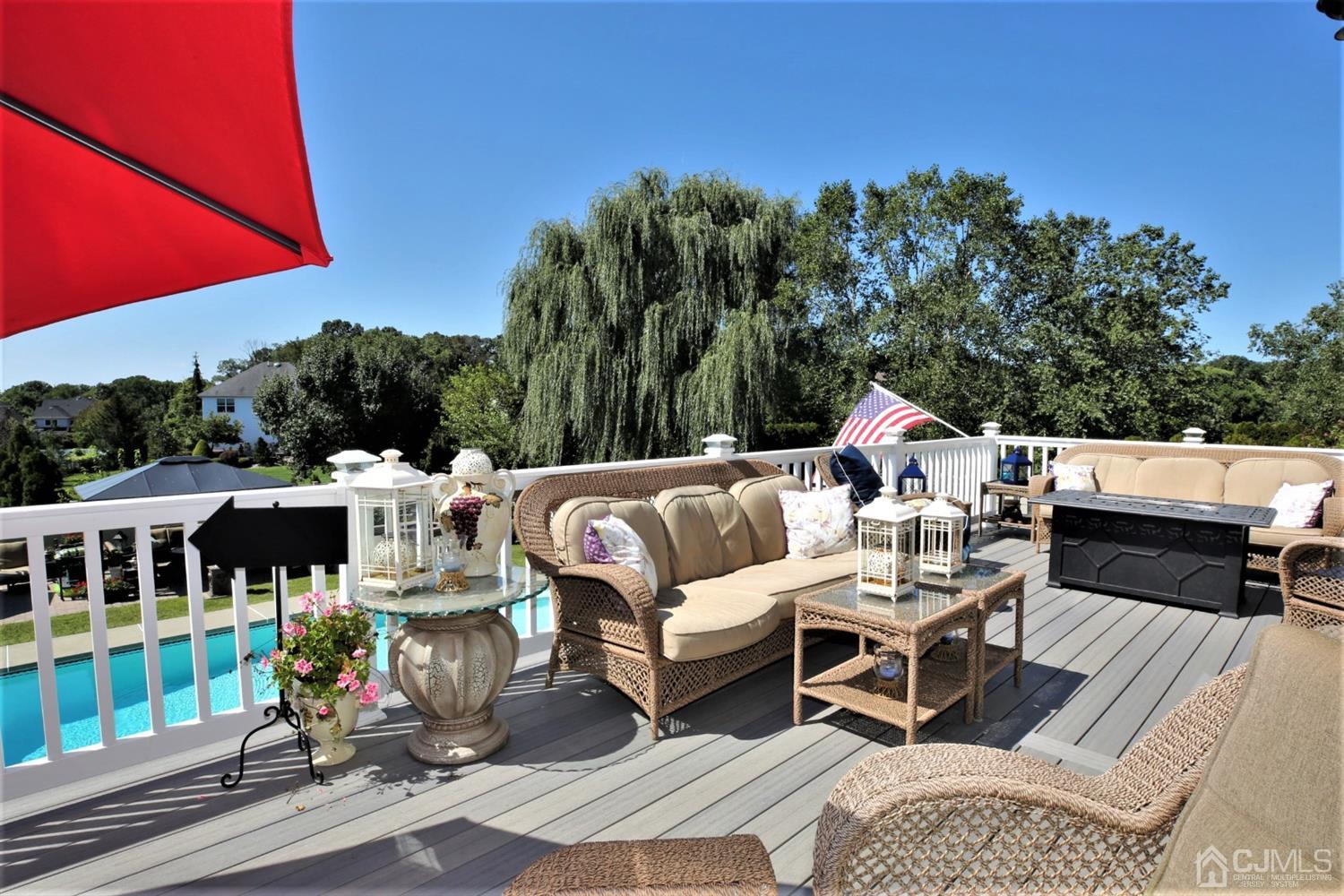 1 MacFarlane Circle Monroe Township, NJ 08831 - Photo 21 of 26 a view of a patio with couches table and chairs under an umbrella