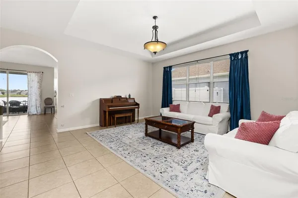 a living room with furniture a chandelier and a rug