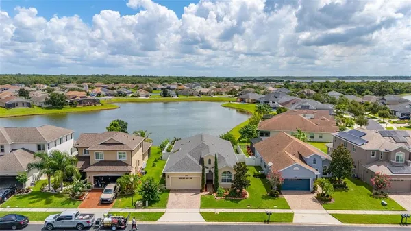an aerial view of house with yard lake and ocean view