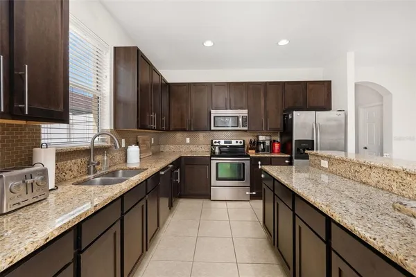 a kitchen with stainless steel appliances granite countertop a sink counter space cabinets and a large window