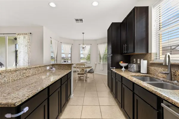 a kitchen with granite countertop a sink and cabinets
