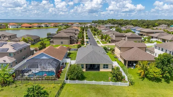an aerial view of residential houses with outdoor space and lake view