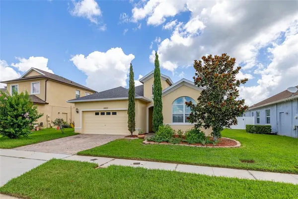 a front view of a house with a garden and trees