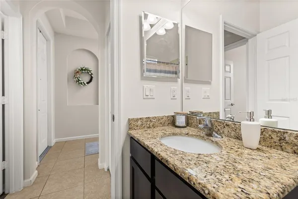 a bathroom with a granite countertop sink and a mirror