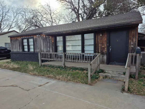 a view of a house with a yard and wooden fence