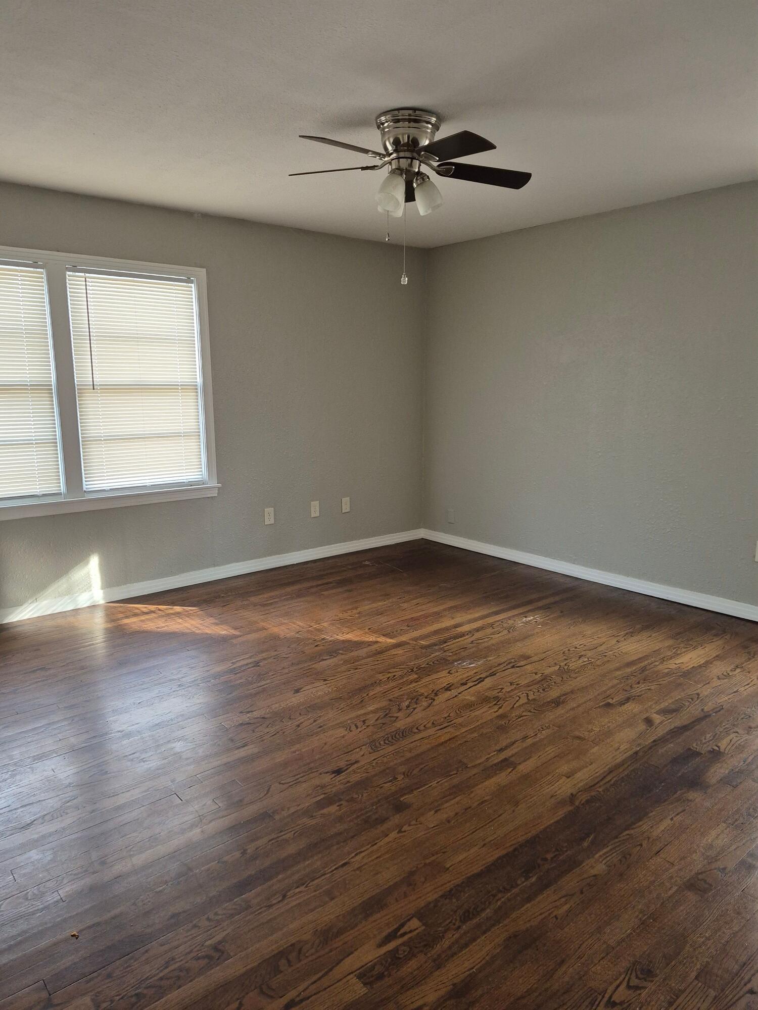 3517 30th Street Lubbock, TX 79410 - Photo 13 of 18 a view of an empty room with wooden floor and a window